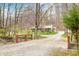 Gravel driveway and small bridge leading to a charming home surrounded by lush greenery and mature trees at 8503 Bean Blossom Rd, Trafalgar, IN 46181
