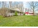 Attractive home with a well-manicured lawn, a inviting porch, and a separate red garage or outbuilding in the background at 8503 Bean Blossom Rd, Trafalgar, IN 46181
