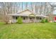 Home with inviting front porch, surrounded by a lush green lawn and mature trees for added privacy at 8503 Bean Blossom Rd, Trafalgar, IN 46181