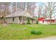 Charming home with a welcoming front porch and a separate red garage or outbuilding on a sprawling green lawn at 8503 Bean Blossom Rd, Trafalgar, IN 46181