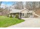 Home with an inviting front porch, surrounded by green grass and mature trees, with a gravel driveway at 8503 Bean Blossom Rd, Trafalgar, IN 46181