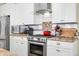 Kitchen showcasing stainless steel appliances, white cabinets, and stylish countertops at 8503 Bean Blossom Rd, Trafalgar, IN 46181