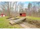 Idyllic backyard landscape with a bridge leading to a rustic red outbuilding at 8503 Bean Blossom Rd, Trafalgar, IN 46181