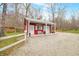 Charming red outbuilding with a covered porch and gravel driveway at 8503 Bean Blossom Rd, Trafalgar, IN 46181