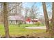 Exterior home with green siding and a red outbuilding with pretty landscaping at 8503 Bean Blossom Rd, Trafalgar, IN 46181