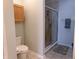 A bathroom with a shower, toilet, and cabinet with a wood finish at 8801 Twain Ln, Indianapolis, IN 46239