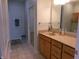 Light-filled bathroom featuring tiled floors, wood cabinets, and a view into the adjoining closet at 8801 Twain Ln, Indianapolis, IN 46239