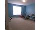 This spacious bedroom is painted blue and features carpet, ample natural light, and exercise equipment at 8801 Twain Ln, Indianapolis, IN 46239