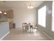 Bright dining area with chandelier lighting, two chairs, and views from the large window at 8801 Twain Ln, Indianapolis, IN 46239