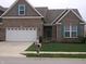 Charming brick home featuring a two-car garage and well-maintained front yard at 8801 Twain Ln, Indianapolis, IN 46239