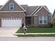 Charming brick home featuring a two-car garage and well-maintained front yard at 8801 Twain Ln, Indianapolis, IN 46239