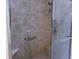 Detailed view of a well-maintained shower with tile surround, glass door, and accessible grab bars at 8801 Twain Ln, Indianapolis, IN 46239
