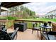 Back deck with outdoor seating, dark chairs, dark storage box, and a lawn in the background at 9010 Ramapo Dr, Fishers, IN 46038