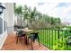 Outdoor deck with table and chairs offering serene views of the green lawn and woods at 9010 Ramapo Dr, Fishers, IN 46038