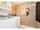 Bright laundry room with white washer, dryer, shelving, storage baskets, and decorative state art on the wall at 9010 Ramapo Dr, Fishers, IN 46038