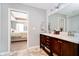 Dual sink bathroom featuring wooden cabinetry and view to the bedroom with tray ceilings at 9010 Ramapo Dr, Fishers, IN 46038
