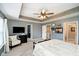 Main bedroom with a tray ceiling, ceiling fan, tv, and a view to the Primary closet at 9010 Ramapo Dr, Fishers, IN 46038