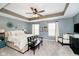 A beautifully designed main bedroom with a tray ceiling, ceiling fan, and chair at 9010 Ramapo Dr, Fishers, IN 46038