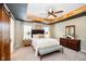 Beautiful main bedroom with tray ceiling, ceiling fan, and sliding barn door at 9010 Ramapo Dr, Fishers, IN 46038