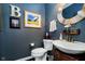 Stylish powder room with rustic wood mirror, dark walls, and traditional fixtures at 9010 Ramapo Dr, Fishers, IN 46038