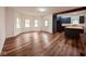 Bright open-concept living room features sleek hardwood floors and a connecting kitchen with dark blue cabinets at 905 W 3Rd St, Anderson, IN 46016