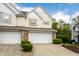 Townhome with a white garage door, yellow shutters and trimmed green bushes at 9338 Eden Woods Ct, Indianapolis, IN 46260