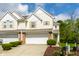 Well-maintained townhome featuring an attached garage and landscaped front yard at 9338 Eden Woods Ct, Indianapolis, IN 46260