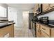 Bright kitchen with stainless steel appliances, light wood cabinets, and black countertops at 9338 Eden Woods Ct, Indianapolis, IN 46260