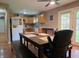 Bright dining area with laminate floors, a ceiling fan, and a large table with bench seating at 935 Fry Rd, Greenwood, IN 46142