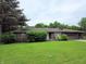 Brick home with mature landscaping including trees and bushes, and a well-maintained lawn at 935 Fry Rd, Greenwood, IN 46142