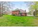 Green backyard with a well-maintained lawn, mature trees, and a cozy deck area at 945 Baywood Ct, Columbus, IN 47201