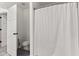 A bathroom with a tub and shower behind a shower curtain and a toilet at 945 Baywood Ct, Columbus, IN 47201