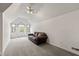 Bright bonus room features natural light, neutral walls, plush carpet, and a comfortable brown couch at 945 Baywood Ct, Columbus, IN 47201