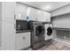 Well-equipped laundry room with cabinets, modern washer, dryer, sink and shelving at 945 Baywood Ct, Columbus, IN 47201