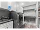 Functional laundry room with modern appliances, cabinets, sink, and ample shelving at 945 Baywood Ct, Columbus, IN 47201