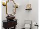 Stylish powder room featuring vessel sink on a dark vanity and ornate gold trimmed mirror at 945 Baywood Ct, Columbus, IN 47201