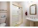 Bathroom featuring a glass shower stall with gold-tone fixtures, sink and white tiled floor at 9838 Gulfstream Ct, Fishers, IN 46037