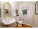 Bathroom with pedestal sink, gold fixtures, framed artwork and window with shade at 9838 Gulfstream Ct, Fishers, IN 46037