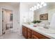 Bright bathroom featuring a double sink vanity with white countertops and warm wood cabinets at 9838 Gulfstream Ct, Fishers, IN 46037