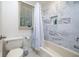 Bathroom with updated marble-style tile surround, white bathtub, and built-in shelving at 9838 Gulfstream Ct, Fishers, IN 46037