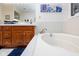 Bathroom showcasing a soaking tub with wooden cabinets and fixtures at 9838 Gulfstream Ct, Fishers, IN 46037