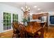 Dining room with hardwood floors, wood table and chairs, and open views to the kitchen and outdoor deck at 9838 Gulfstream Ct, Fishers, IN 46037