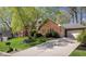 View of a brick home with well maintained grounds and a large driveway leading to attached garages at 9838 Gulfstream Ct, Fishers, IN 46037