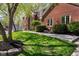 A brick house is shown with lush, mature landscaping including trees, shrubs and a stone border at 9838 Gulfstream Ct, Fishers, IN 46037