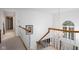 Upstairs hallway with neutral carpet, white banister, wood railing, and chandelier lighting at 9838 Gulfstream Ct, Fishers, IN 46037