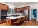 Kitchen featuring stainless steel appliances, white stone countertops, wooden cabinetry, and seating around the island at 9838 Gulfstream Ct, Fishers, IN 46037