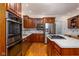 Modern kitchen with stainless steel appliances, kitchen island with gas cooktop and hardwood flooring at 9838 Gulfstream Ct, Fishers, IN 46037