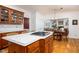 Open kitchen features a stone countertop island with a gas cooktop, wood cabinets, and a view into the dining room at 9838 Gulfstream Ct, Fishers, IN 46037
