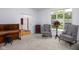Bright living room with checkered chairs, piano and large windows overlooking the yard at 9838 Gulfstream Ct, Fishers, IN 46037
