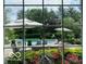 View from window showing the backyard pool, patio, and landscaped garden with blooming flowers at 10605 Winterwood, Carmel, IN 46032